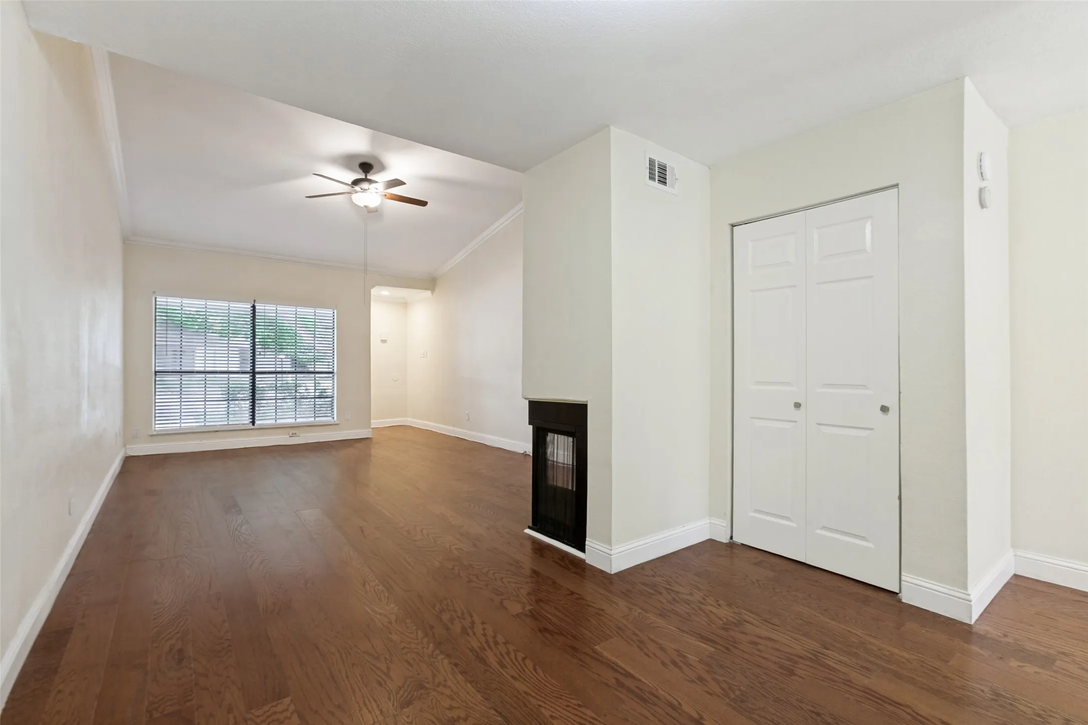 Living area featuring wood-finish flooring, vaulted ceilings, and a ceiling fan