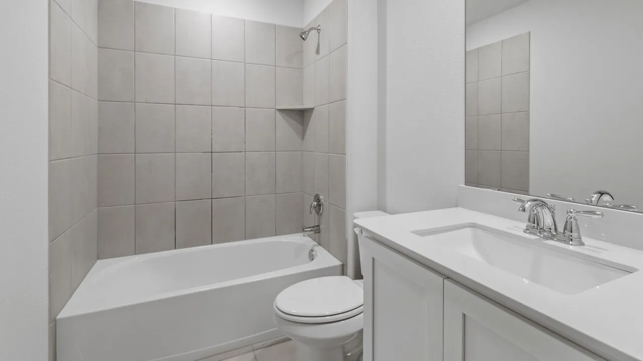 Clean and functional bathroom featuring a white ceramic pedestal sink with chrome faucet, white subway tile walls, an alcove bathtub with shower combination, and a white toilet