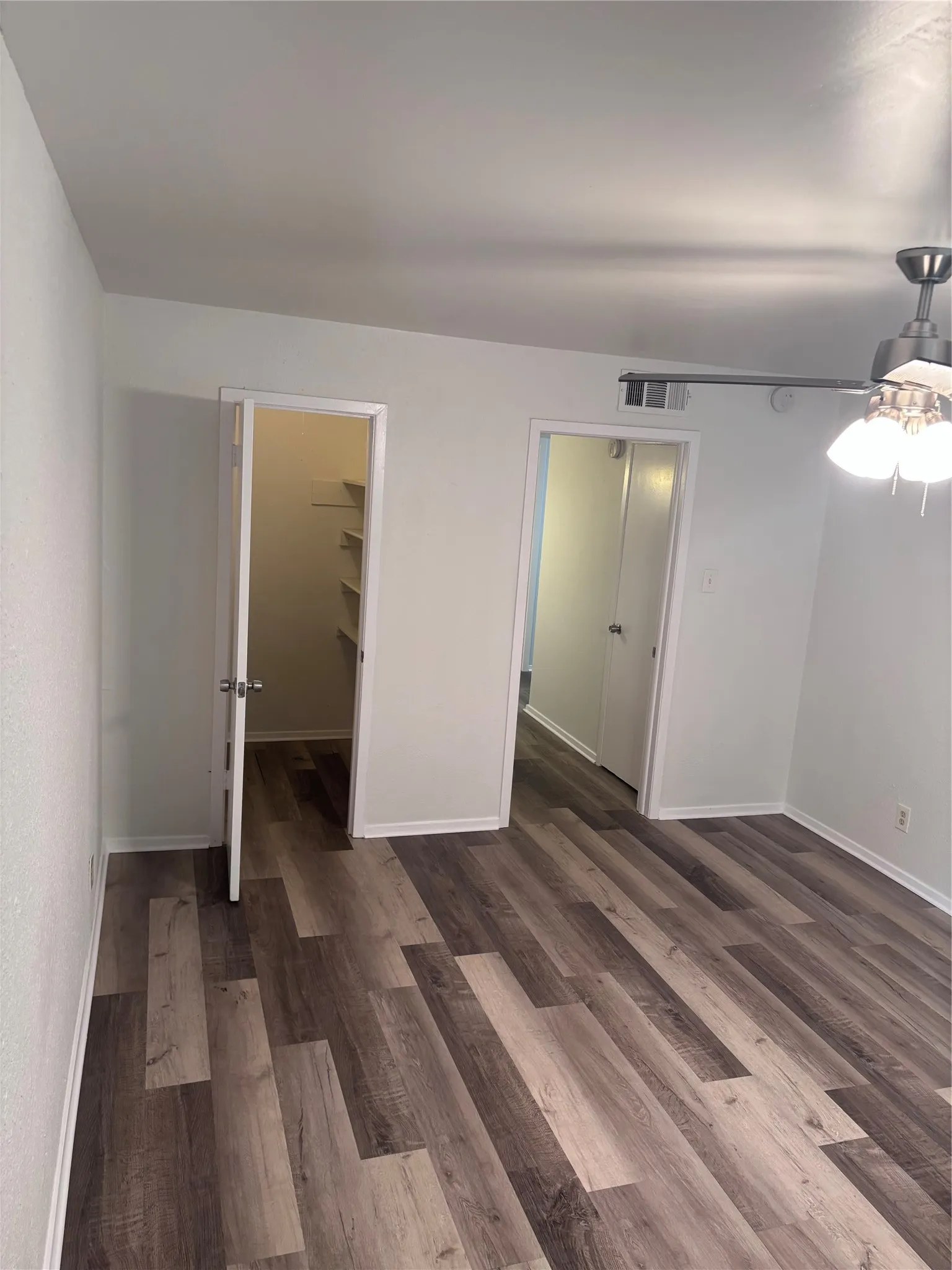 Spacious room showcasing newly installed wood-finish plank flooring throughout
