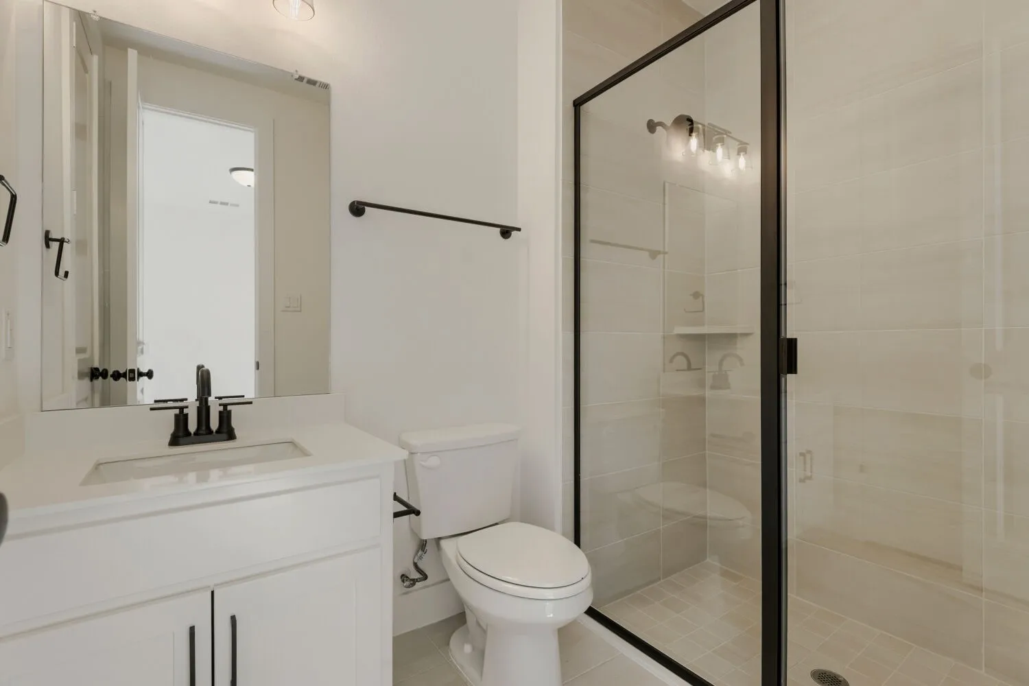 White vanity with a rectangular undermount sink, matte black faucet, and white countertop
