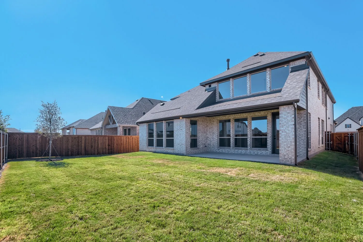 Expansive green lawn with a privacy fence