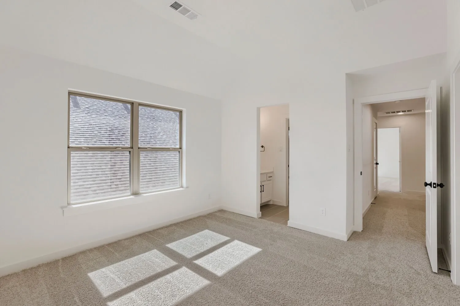 Wall-to-wall carpeting, multiple doorways, and a window with blinds