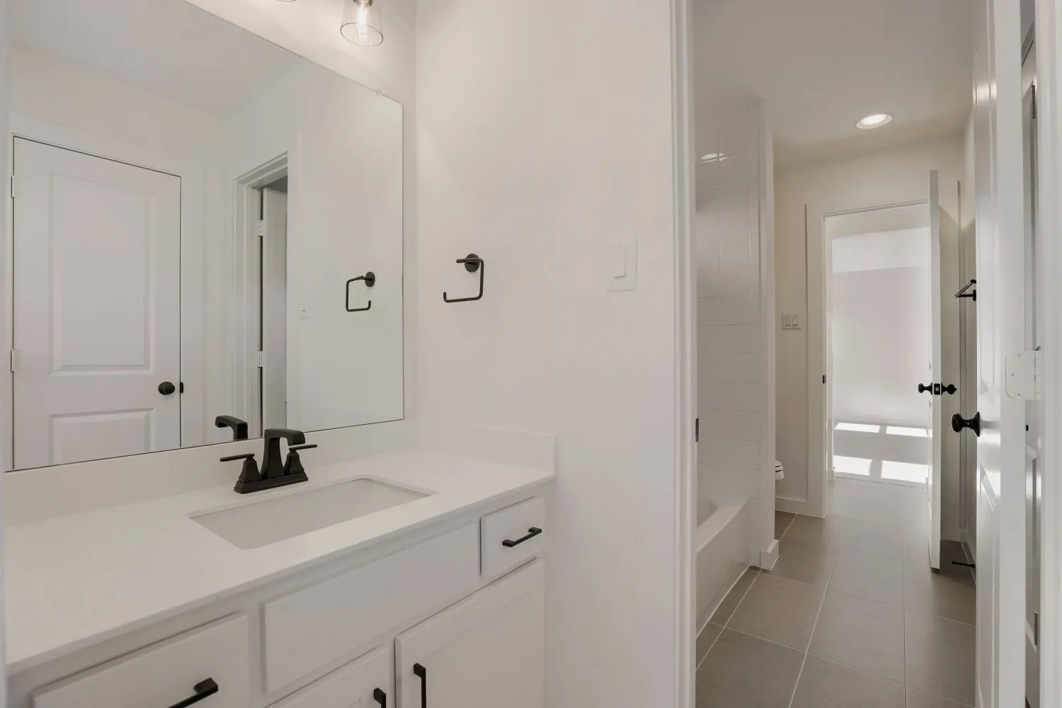 Integrated vanity with white countertop, undermount sink, and matte black faucet
