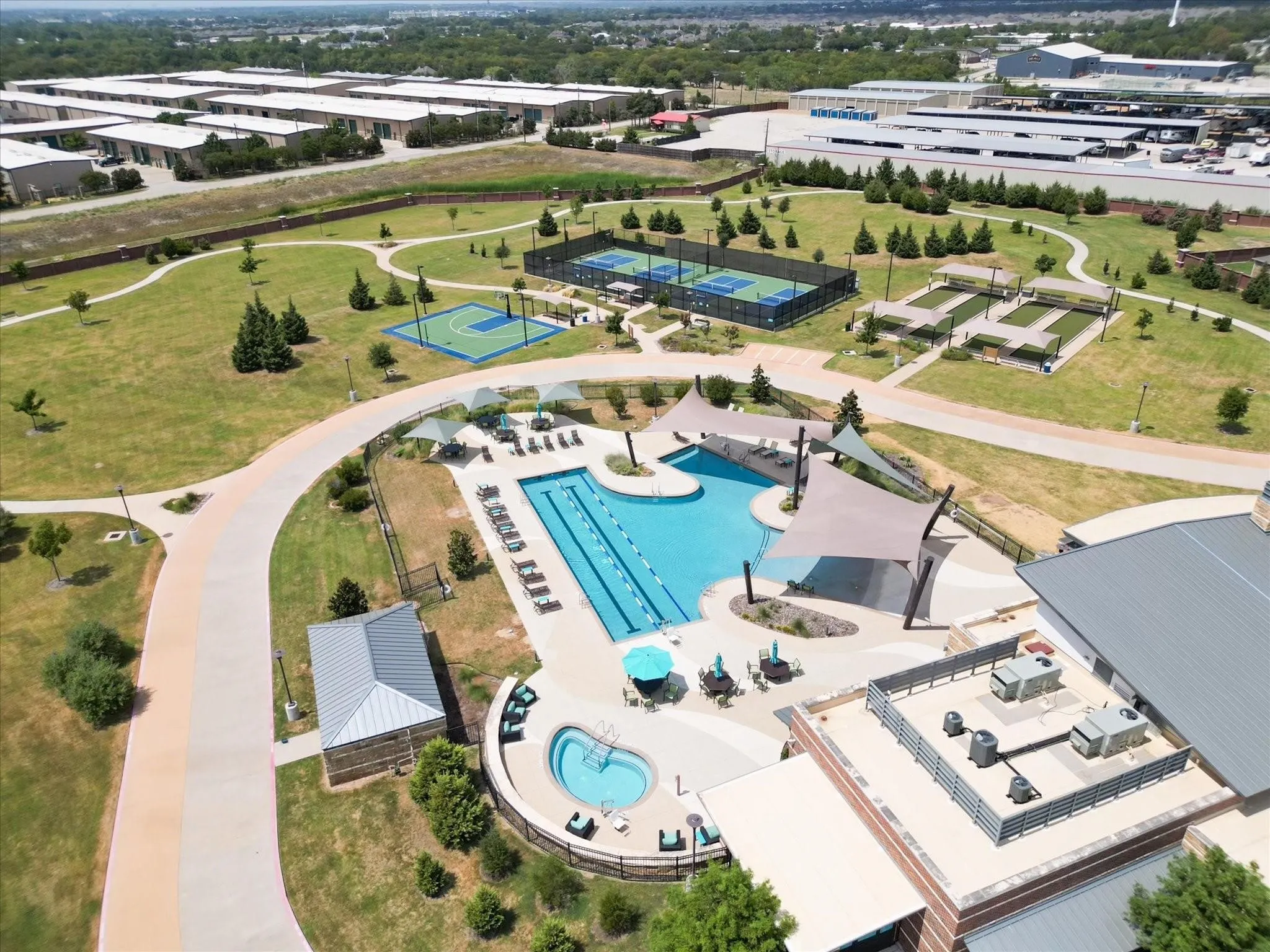 Northside Community recreation area featuring a large swimming pool, separate hot tub, and multiple shade structures