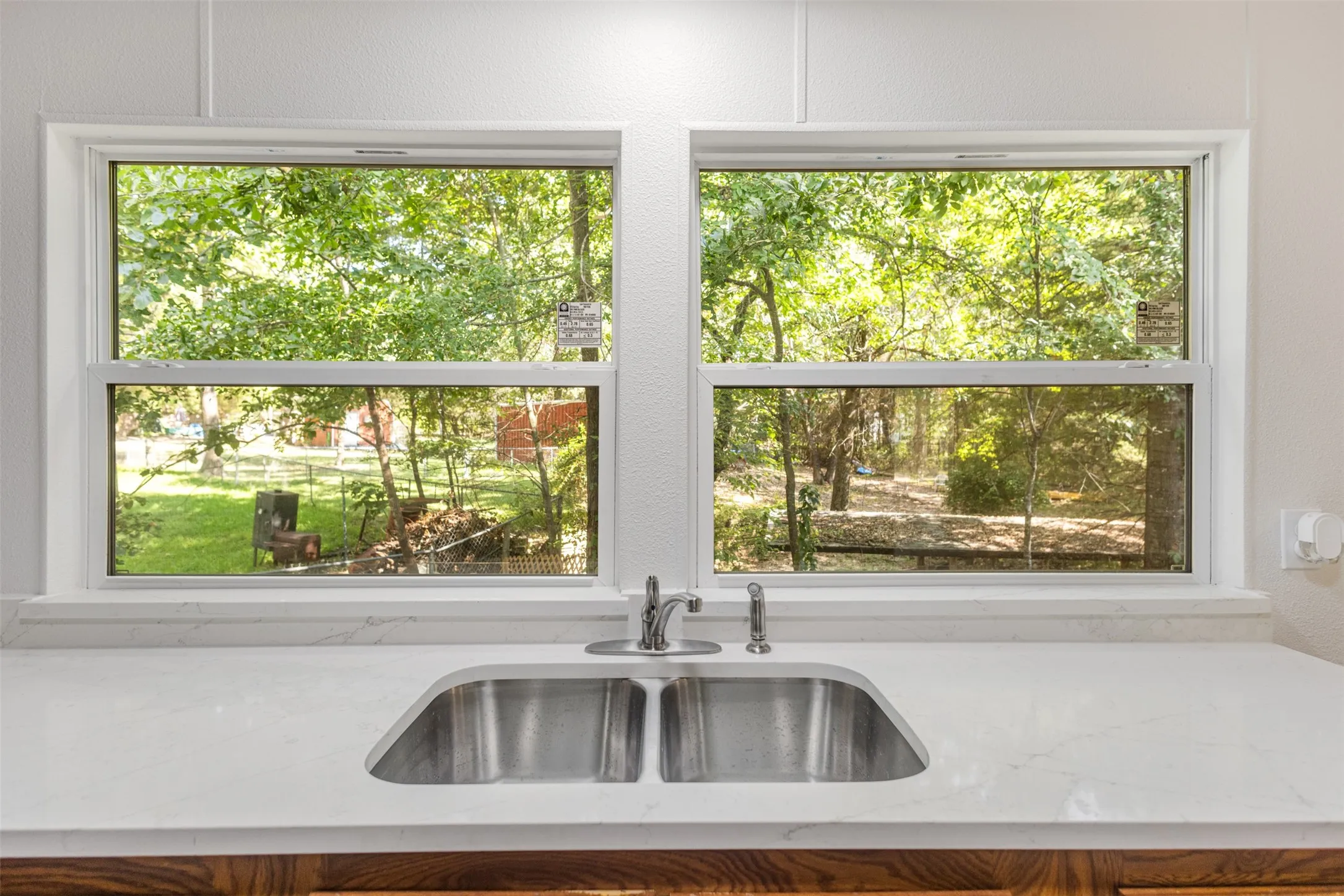 Kitchen showing brand new windows and quartz counter tops.