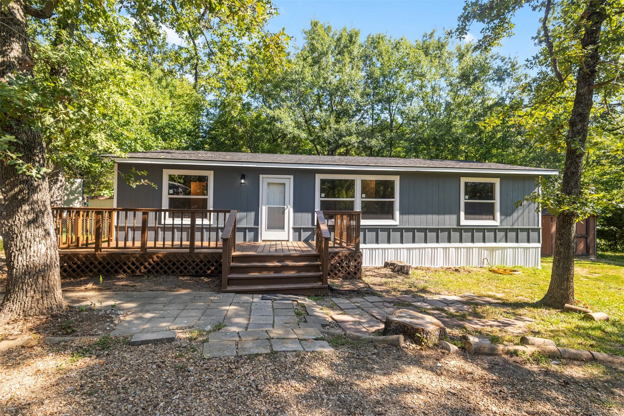 Front of home with a large deck and freshly painted.