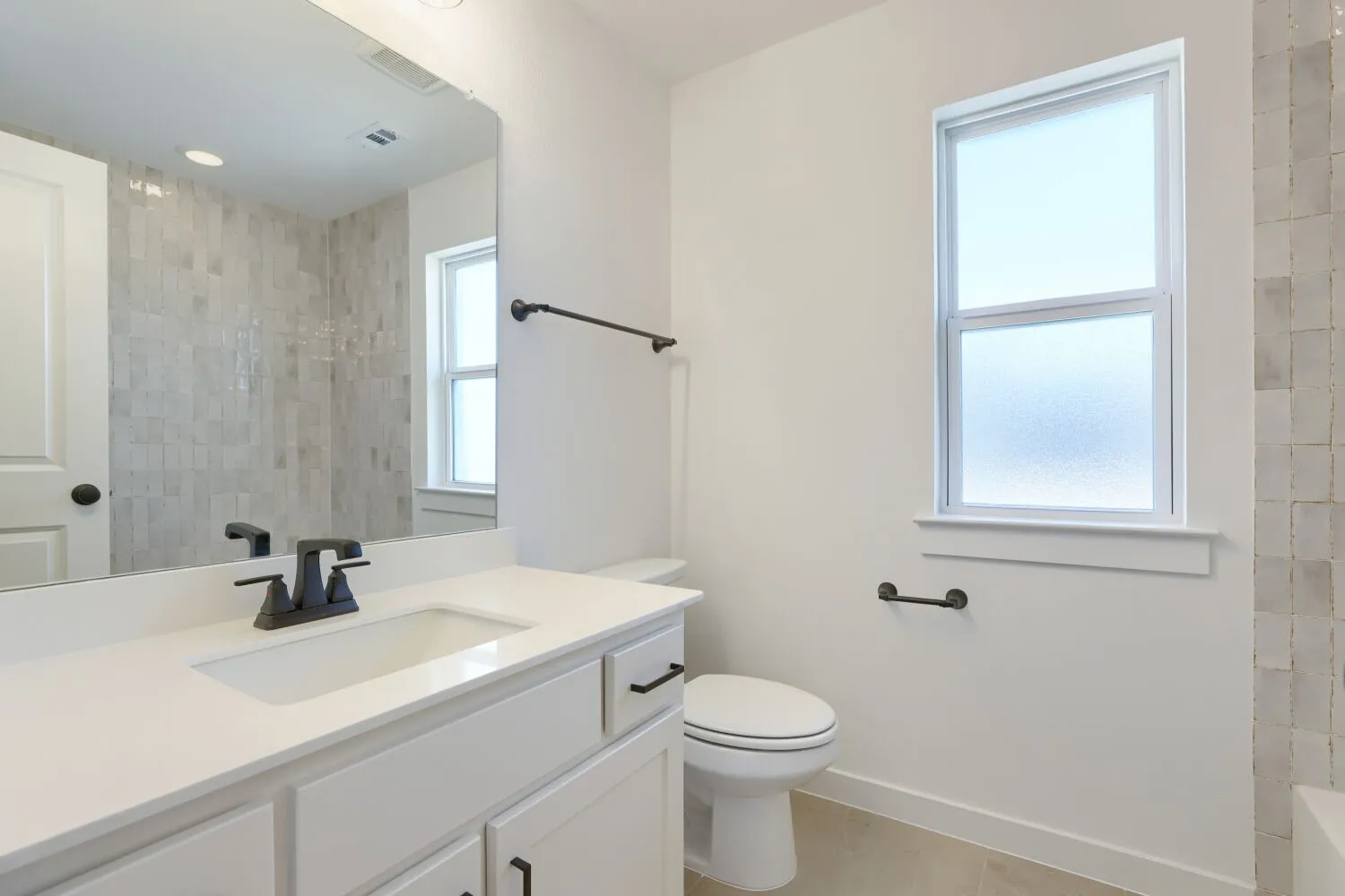 White vanity with a single integrated sink, quartz countertop, and matte black faucet