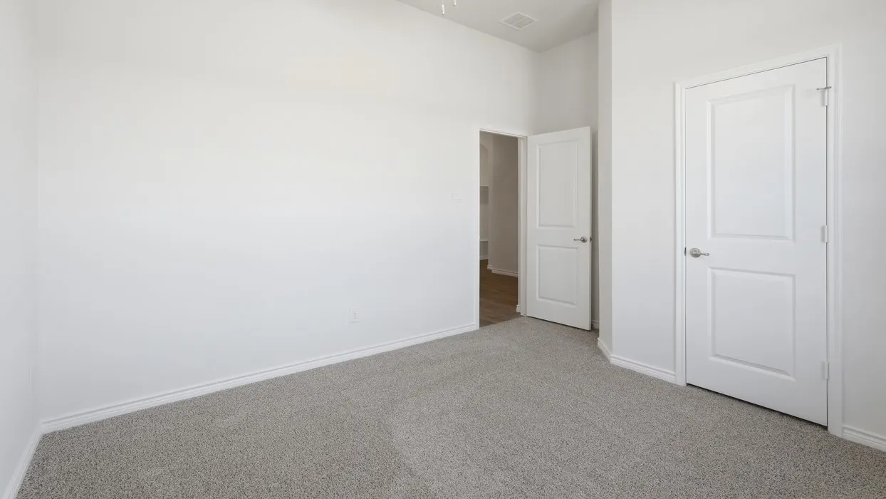 Carpeted room featuring white walls, white trim, and two paneled interior doors with brushed nickel hardware