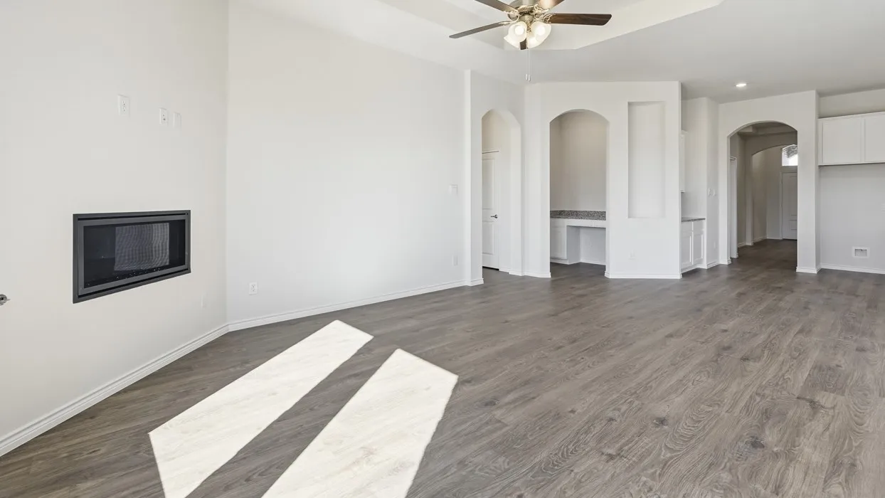 Spacious open-concept living area featuring wood-finish flooring throughout, recessed lighting, and a ceiling fan