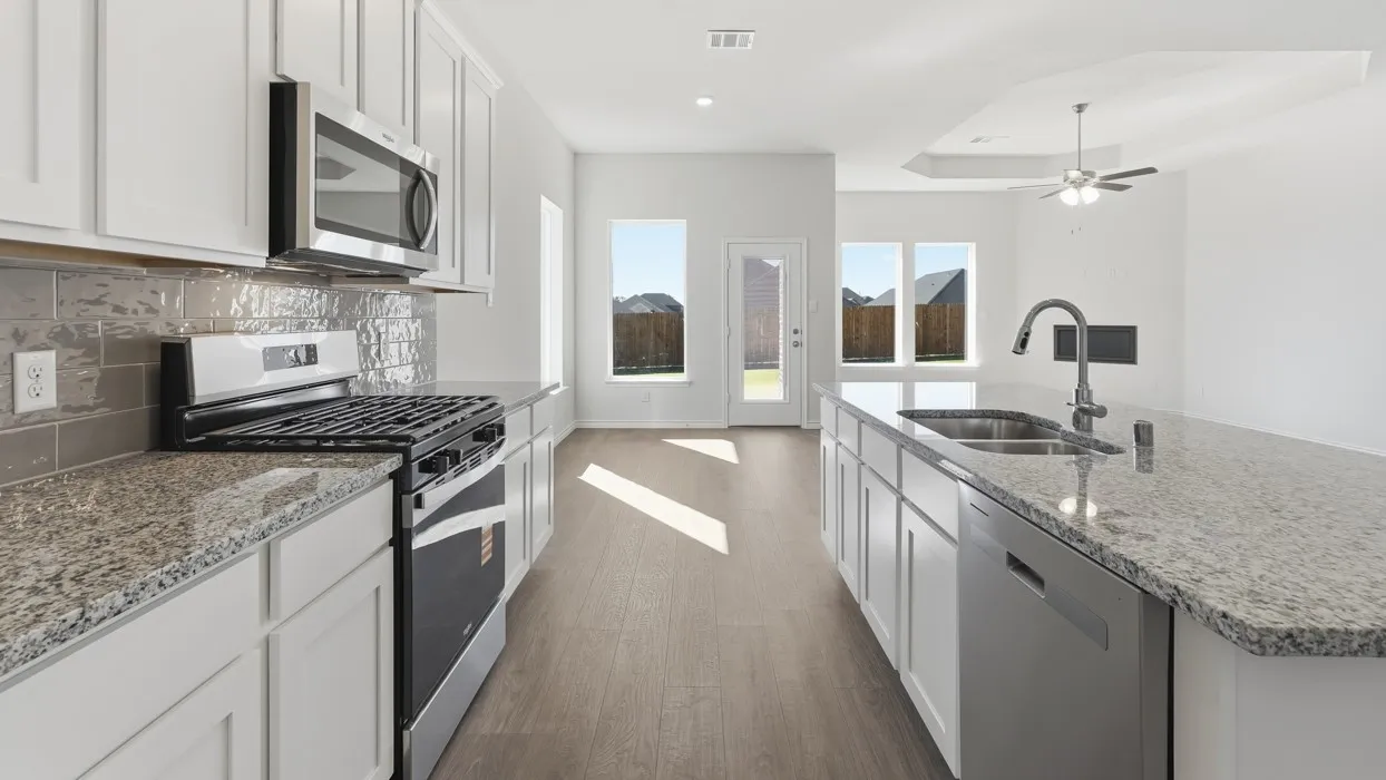 Chef's kitchen featuring white cabinetry, granite countertops, stainless steel appliances including a gas range and dishwasher, a deep undermount sink with matte black faucet, subway tile backsplash, and wood-finish flooring throughout