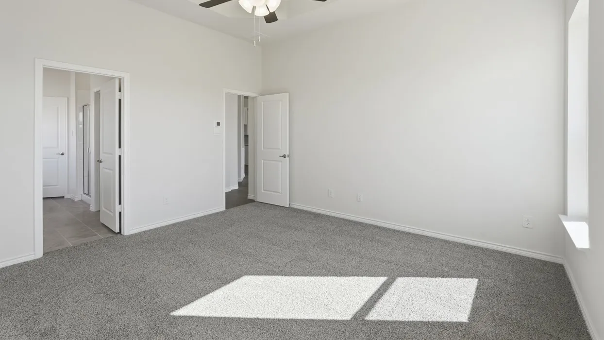 Spacious bedroom with neutral wall finishes, gray carpet flooring, and abundant natural light from large windows