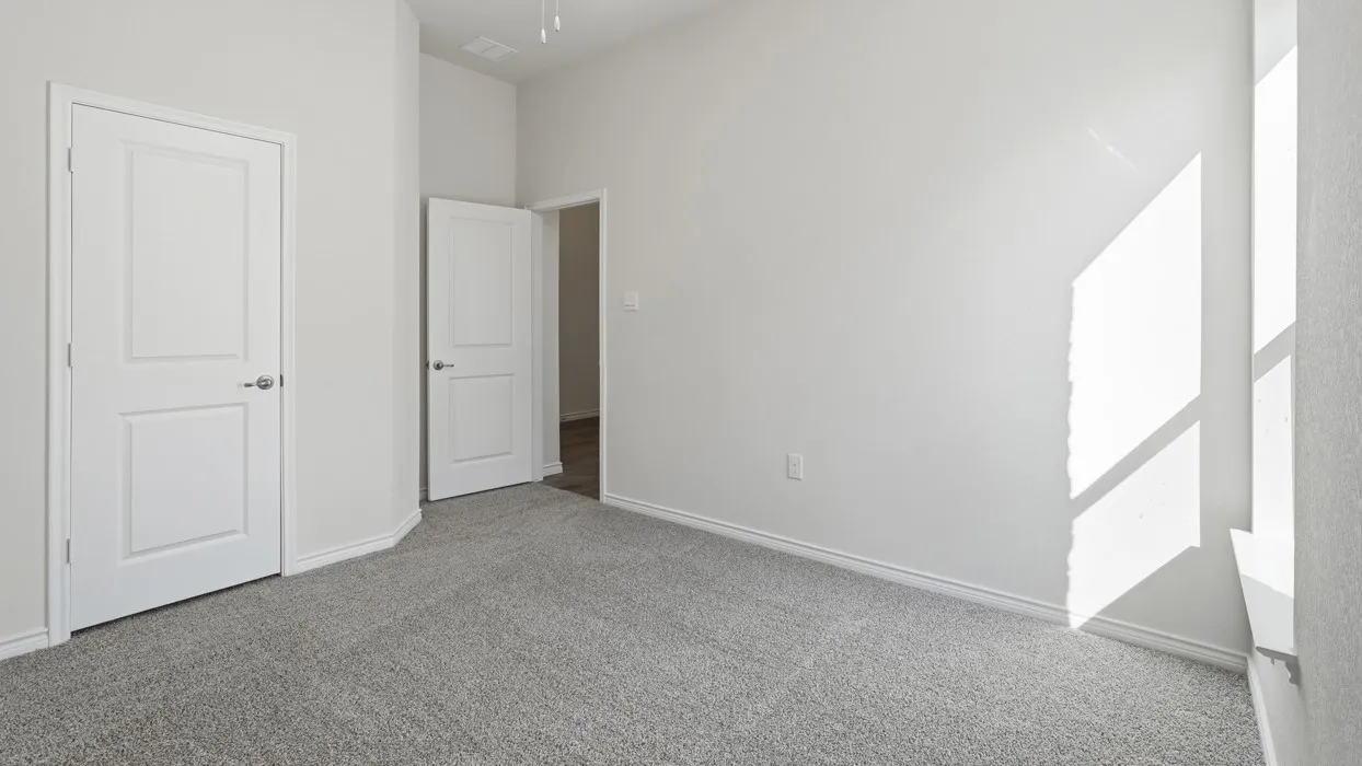 Carpeted room featuring white walls, white trim, and two-panel interior doors with brushed nickel hardware