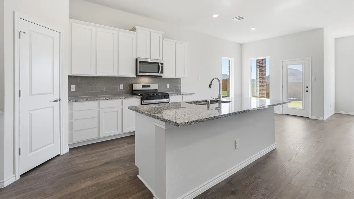Modern kitchen featuring a central island with an undermount sink and gooseneck faucet