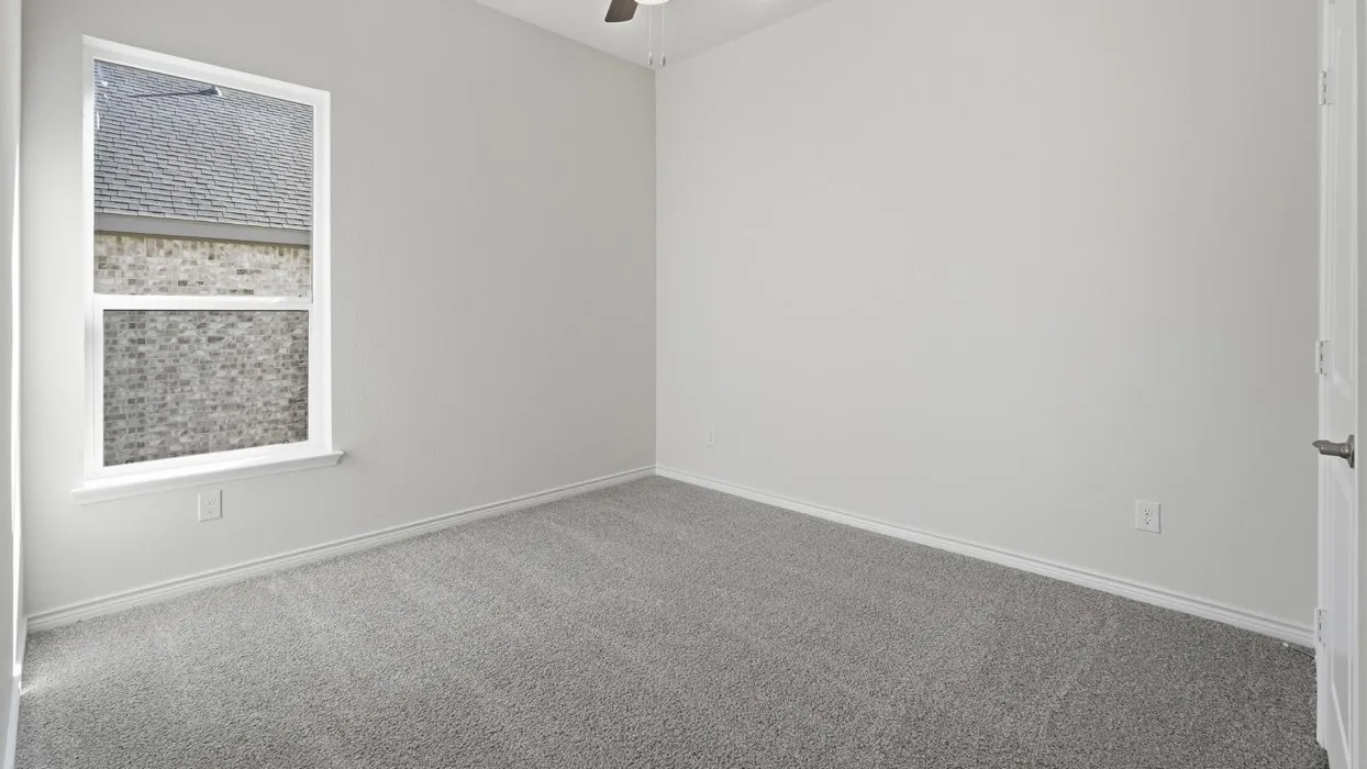 Bright bedroom featuring neutral wall finishes, generous natural light from a large window, and neutral-tone carpet flooring throughout