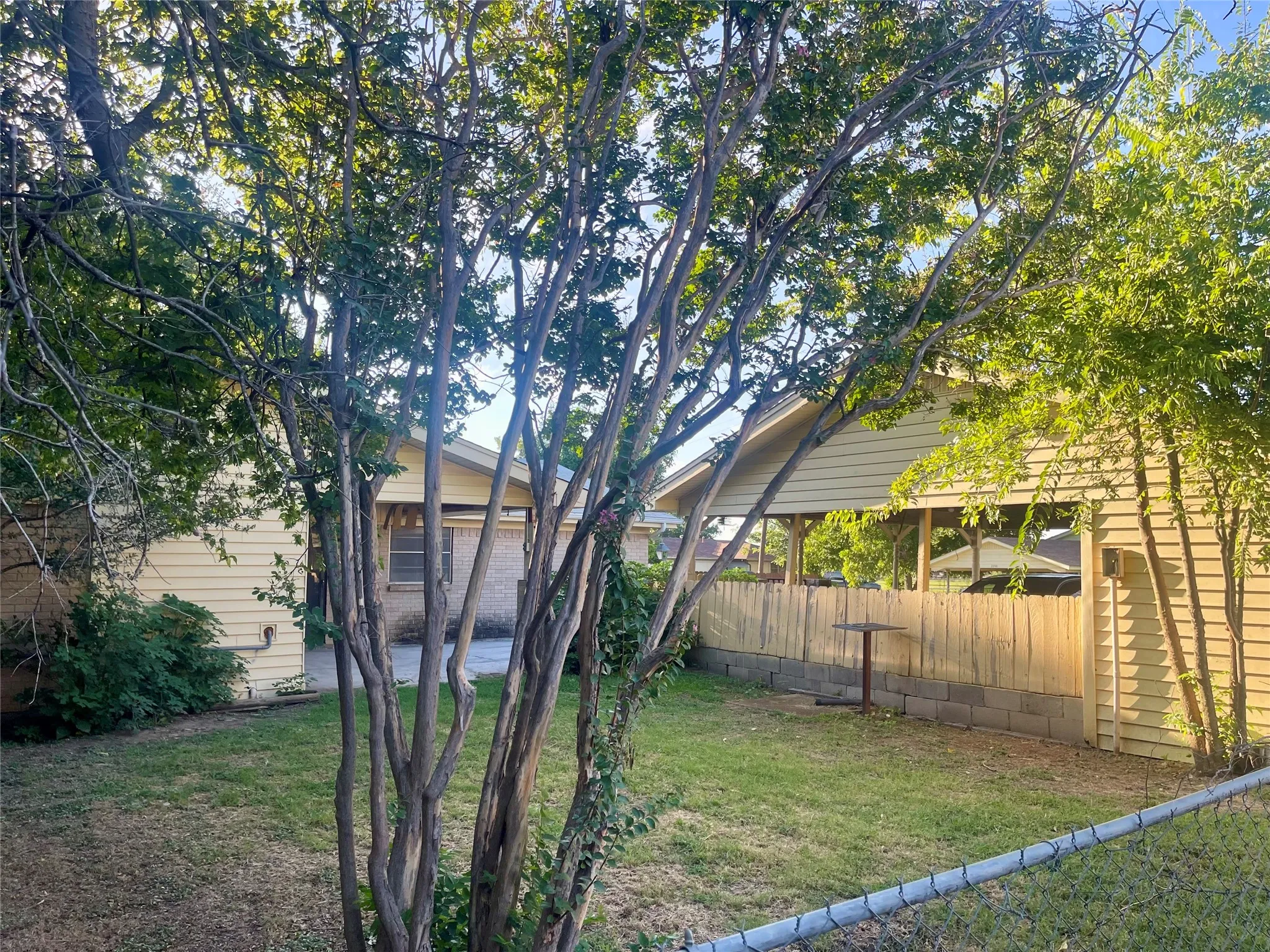 Spacious backyard with mature shade trees.
