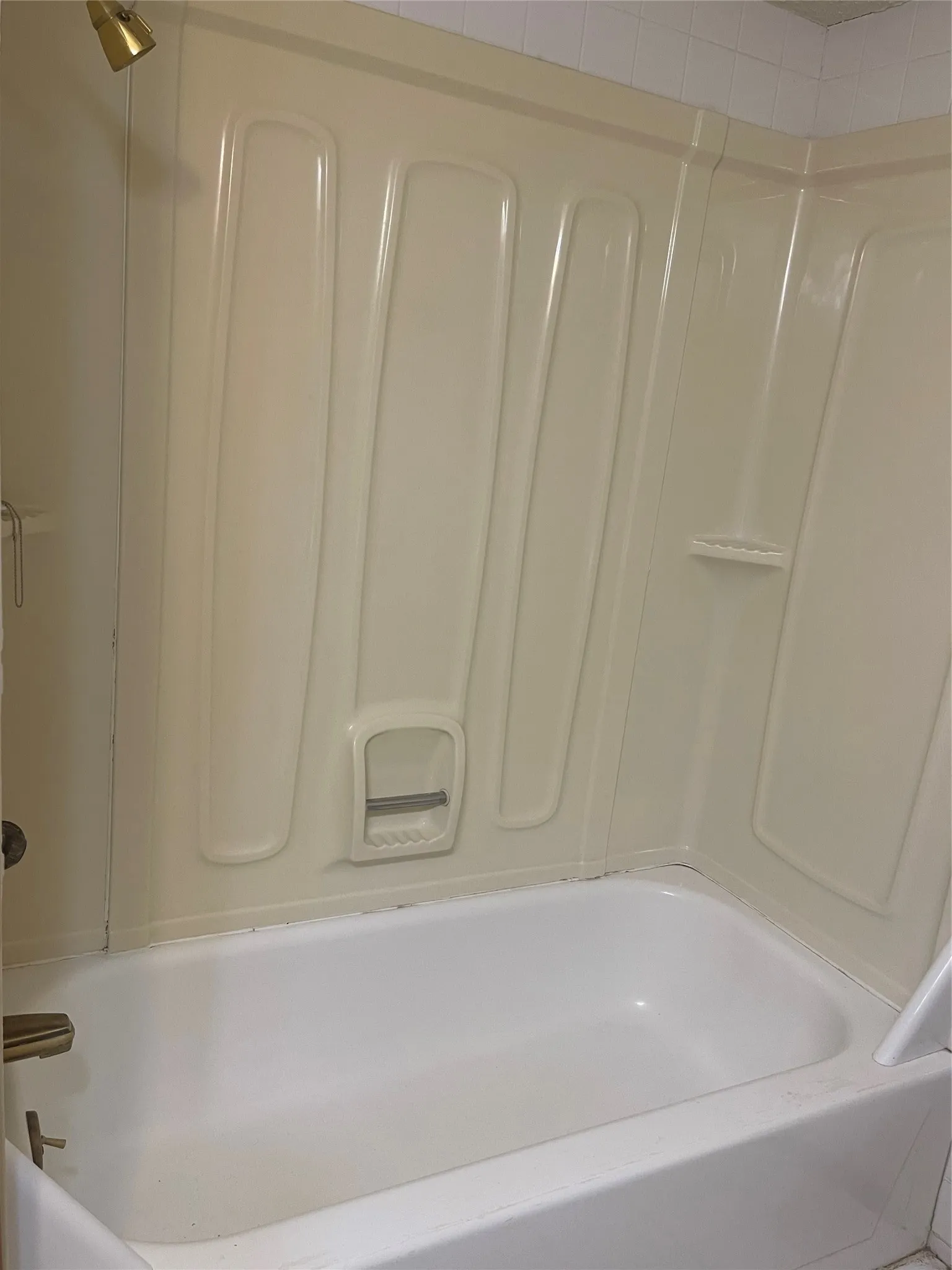 Clean, functional bathroom featuring a spacious soaking tub with integrated surround walls in durable acrylic construction