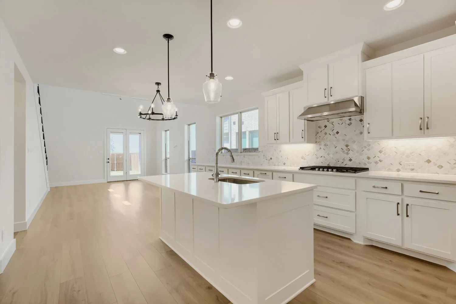 Kitchen featuring a central island, white cabinetry, a decorative tile backsplash, recessed lighting, and wood-finish flooring