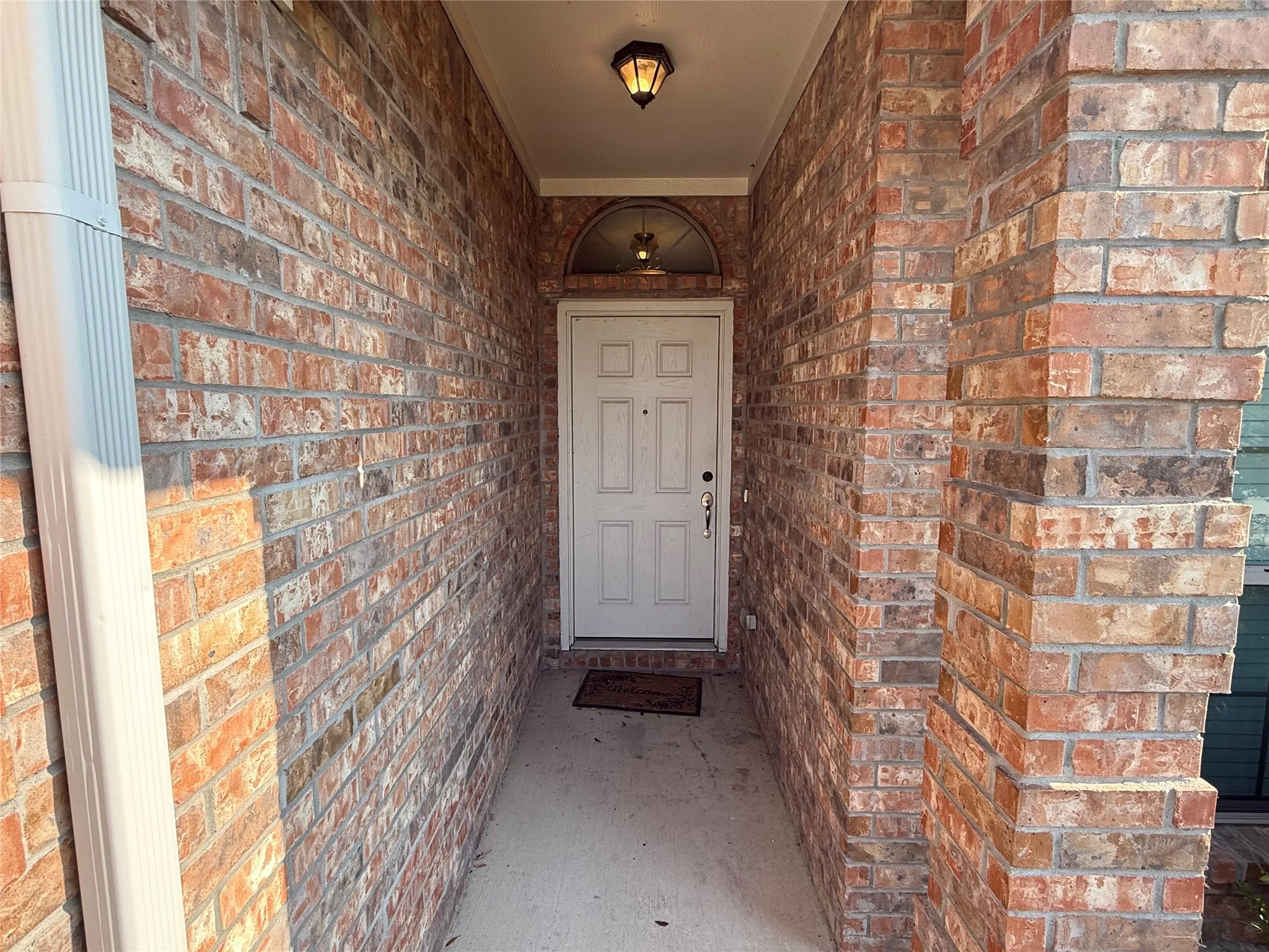 Welcoming entry vestibule framed by authentic red brick walls on both sides