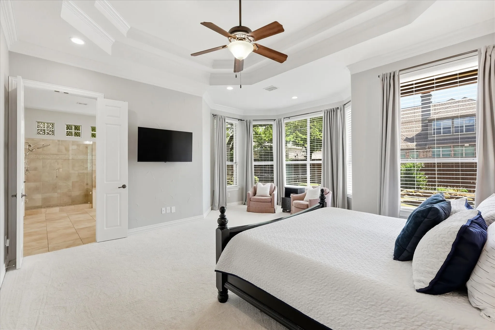 This wall of windows in the primary bedroom overlooks the stunning pool out back.