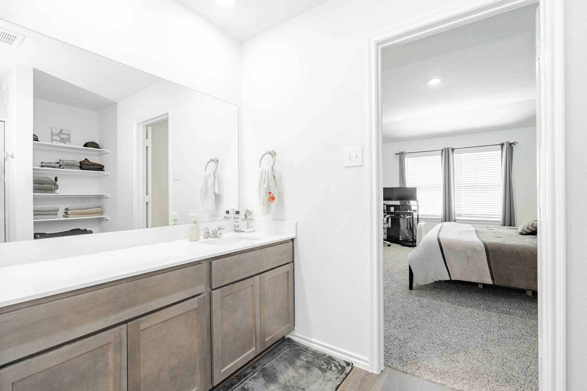 Bathroom featuring connected bathroom, baseboards, recessed lighting, and vanity