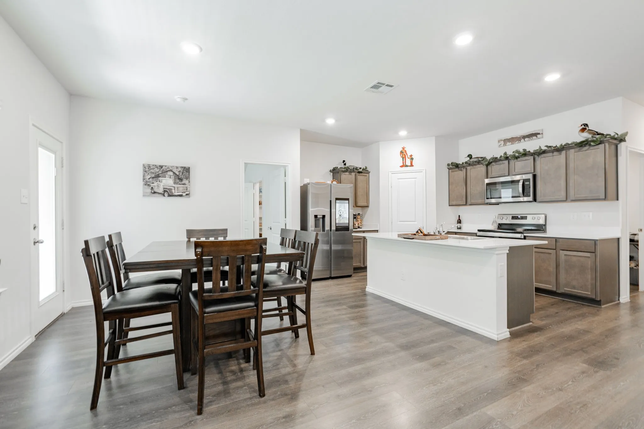Dining area featuring visible vents, wood finished floors, and recessed lighting