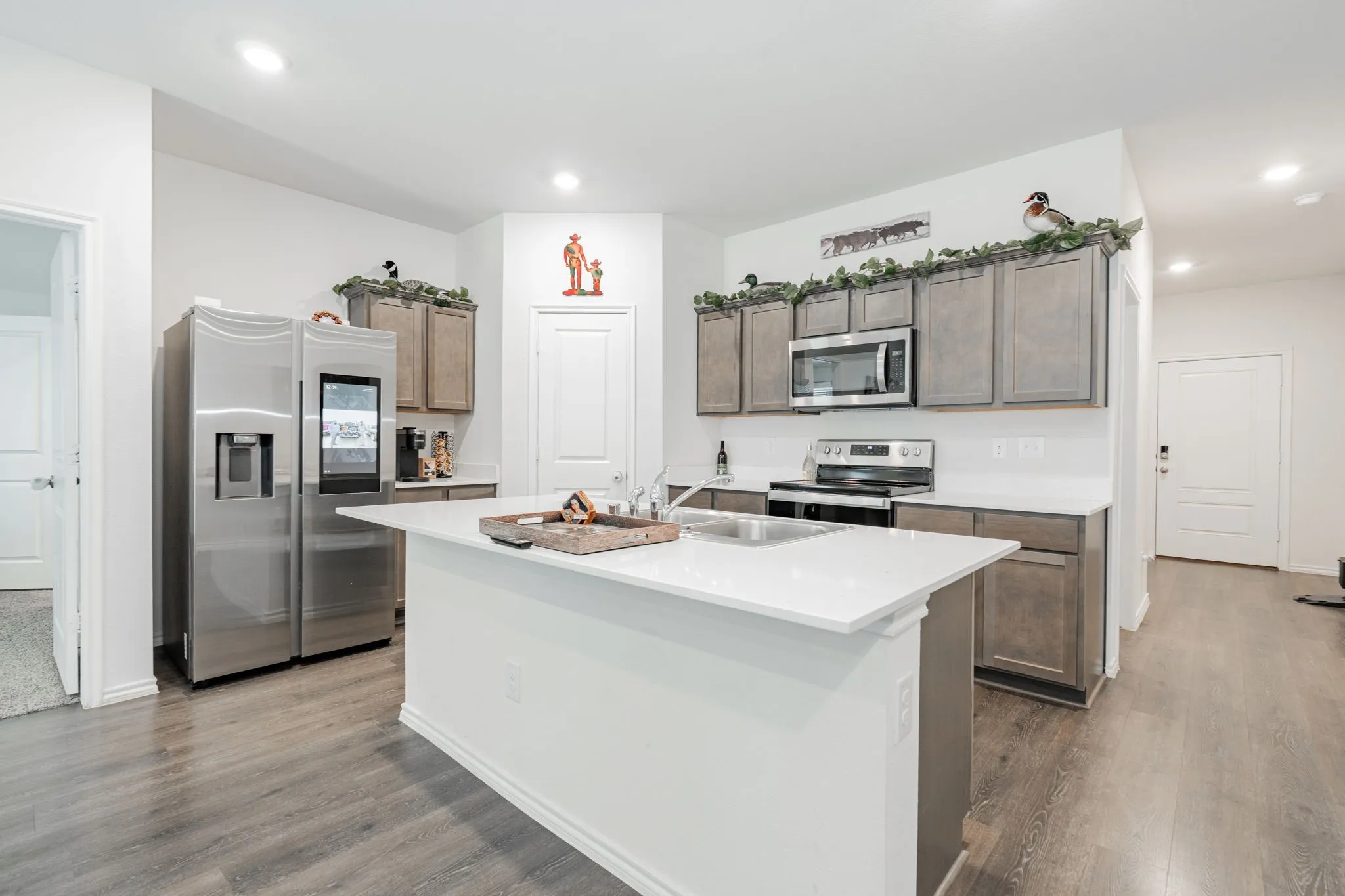 Kitchen with a sink, recessed lighting, wood finished floors, and appliances with stainless steel finishes