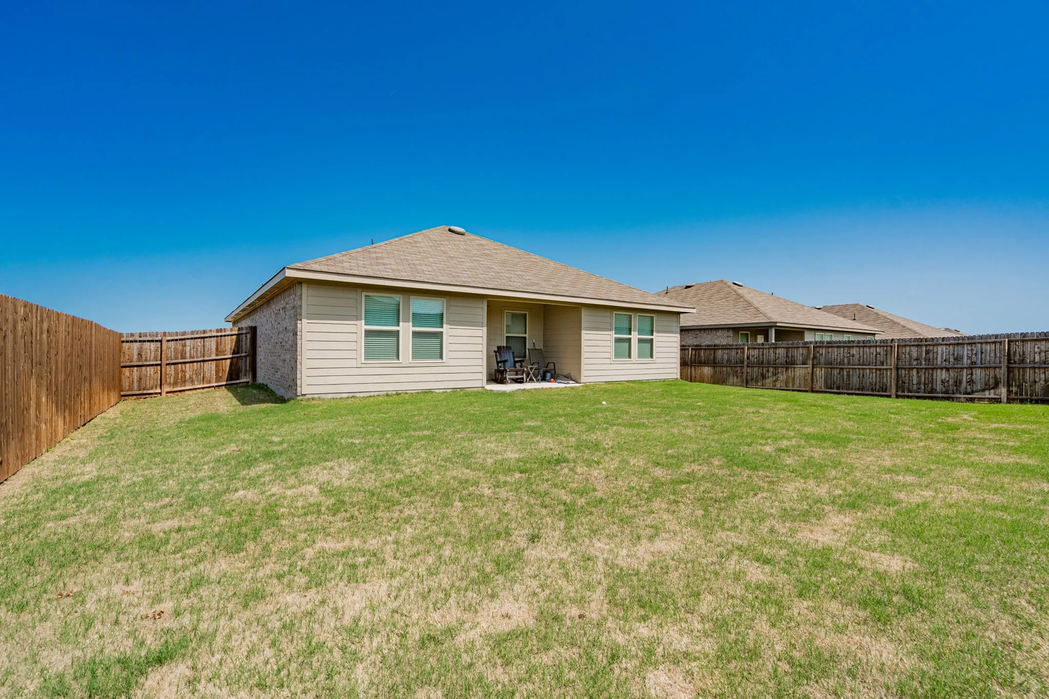 Back of house featuring a fenced backyard and a yard