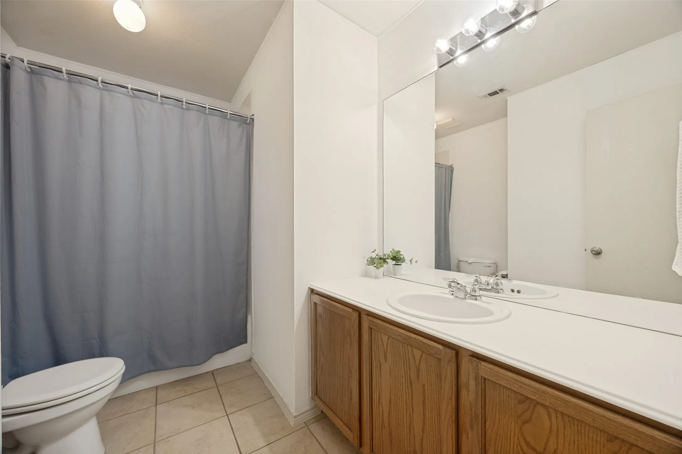 Bathroom featuring a spacious vanity with an integrated sink, ample countertop space, and wood-finish cabinetry
