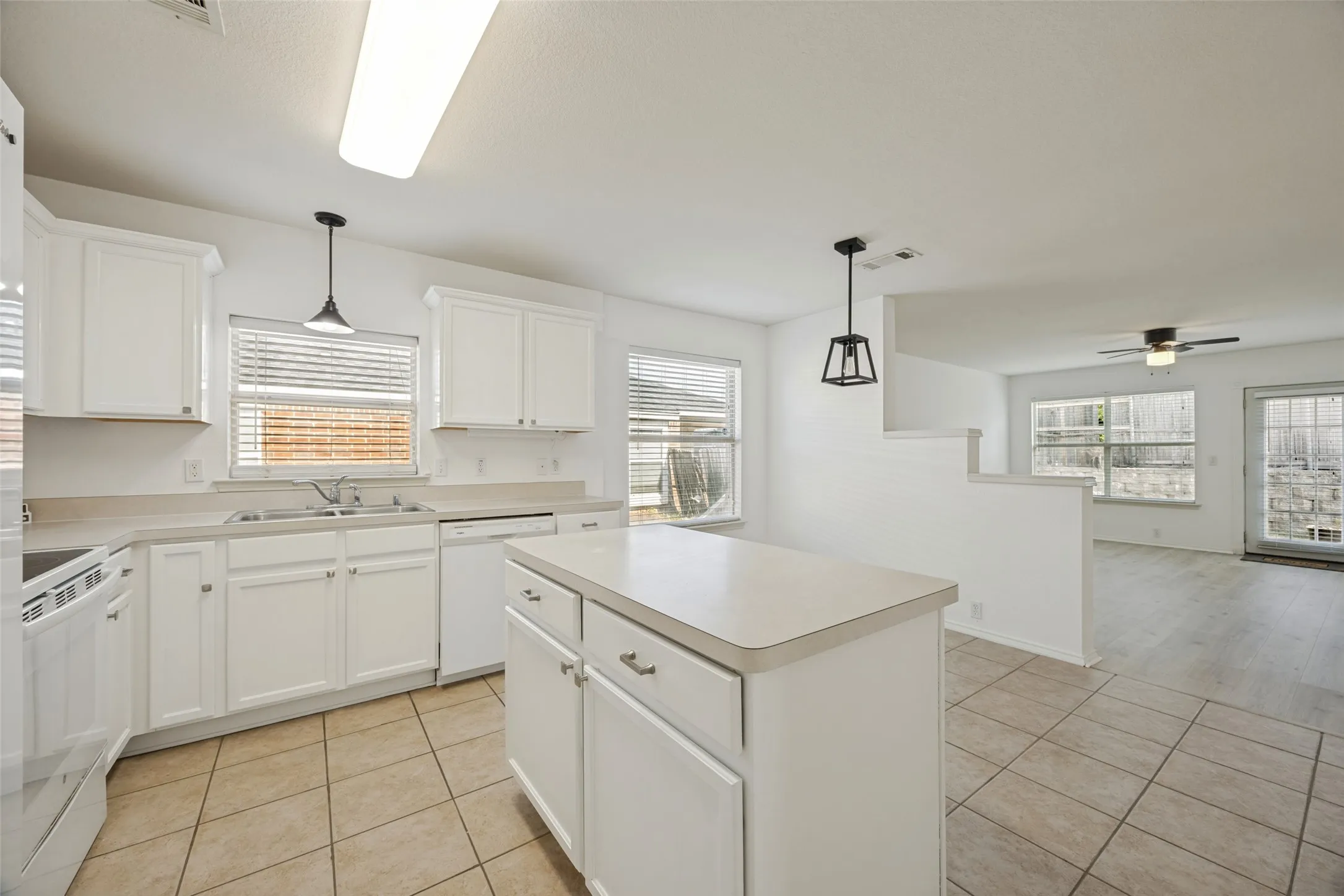 Kitchen featuring white cabinetry, a center island, and tile flooring