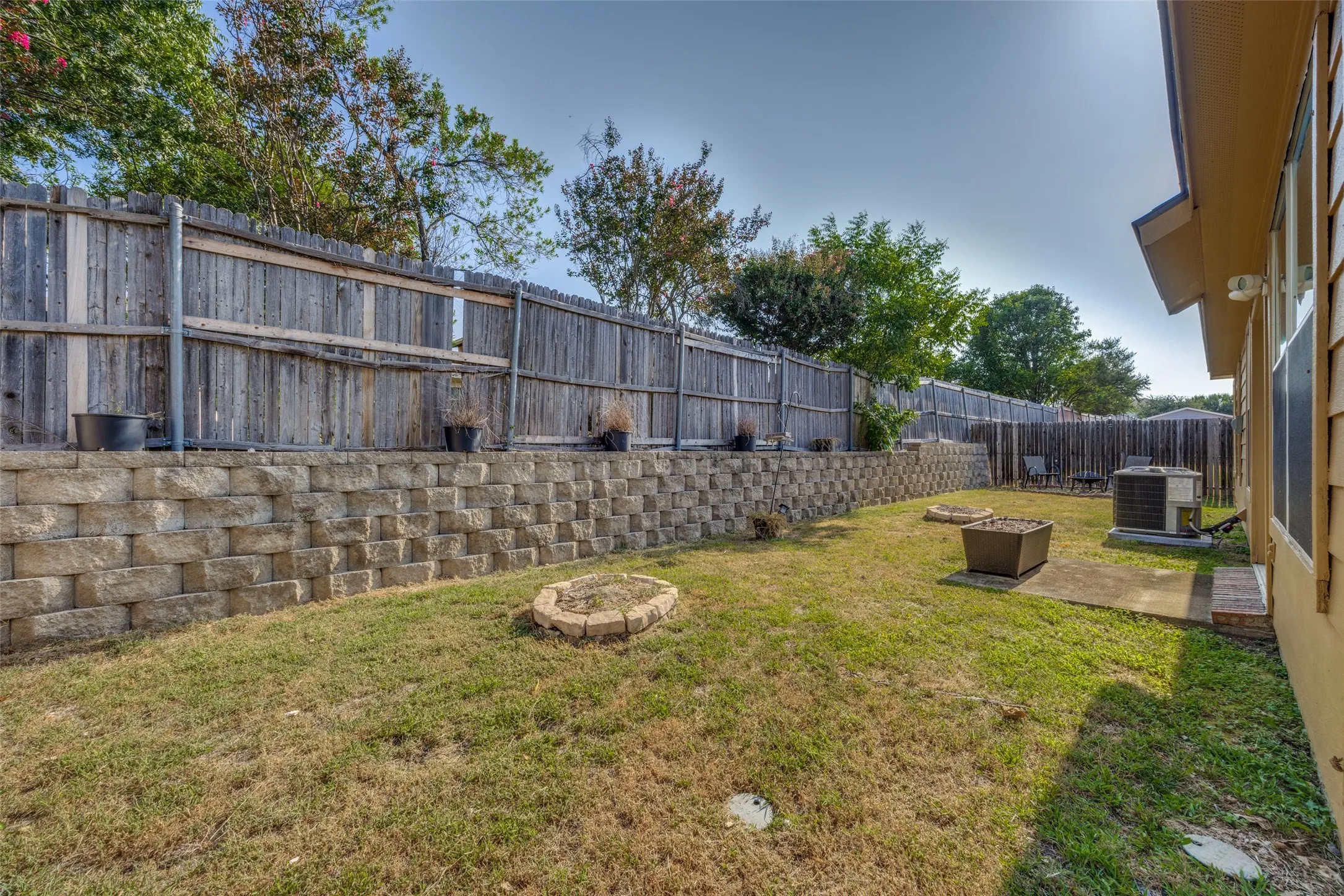 Tiered retaining wall system, privacy fencing, and a concrete patio pad