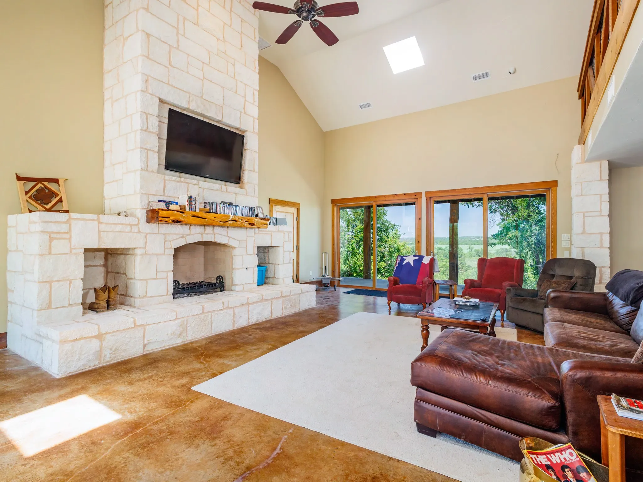 Spacious living room with dramatic fireplace.  Most furniture conveys.  Flooring is stained concrete