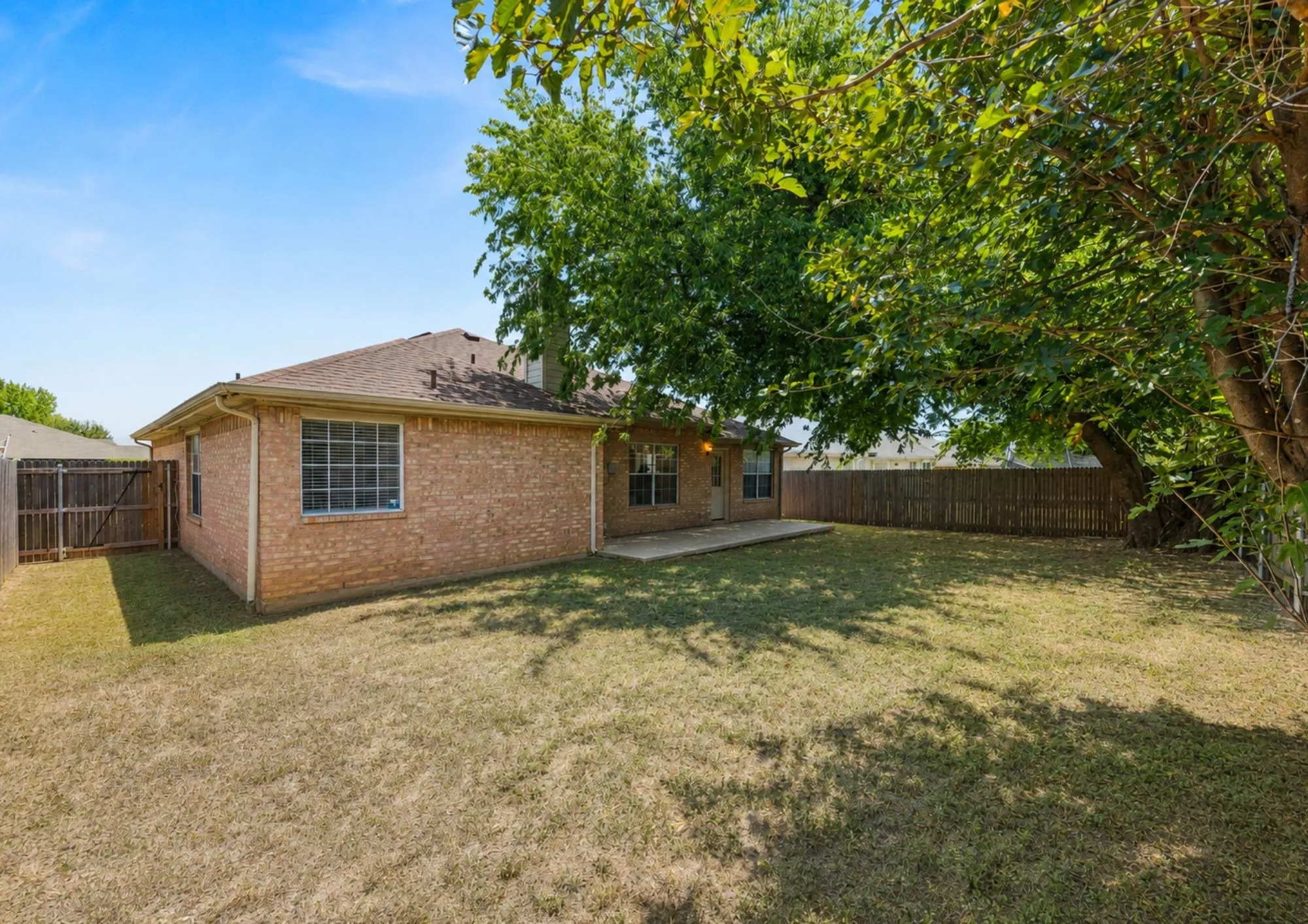 Brick residence with expansive rear grounds featuring mature shade trees and level lawn space