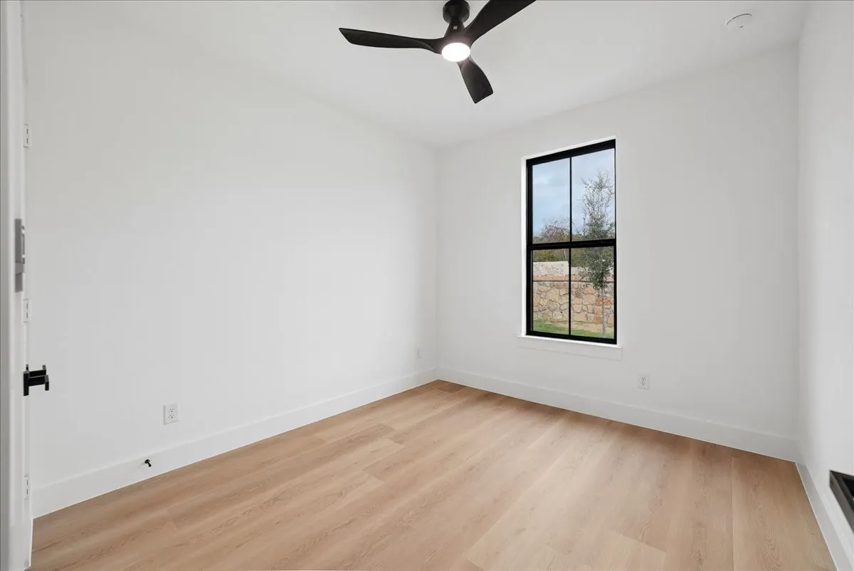 Wood-finish flooring with a modern black ceiling fan and recessed lighting