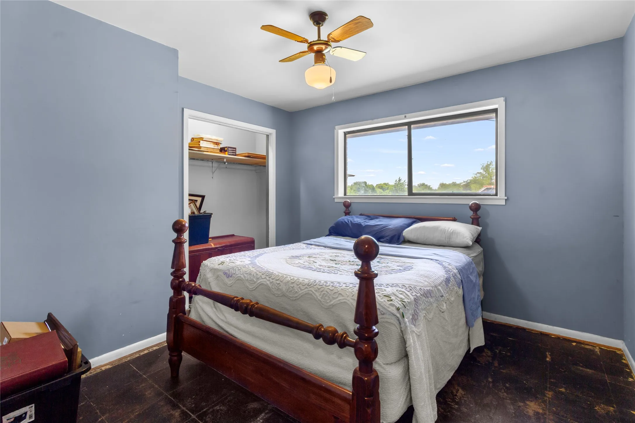 Bedroom featuring a ceiling fan with integrated lighting, a window with exterior views, and an open closet with shelving