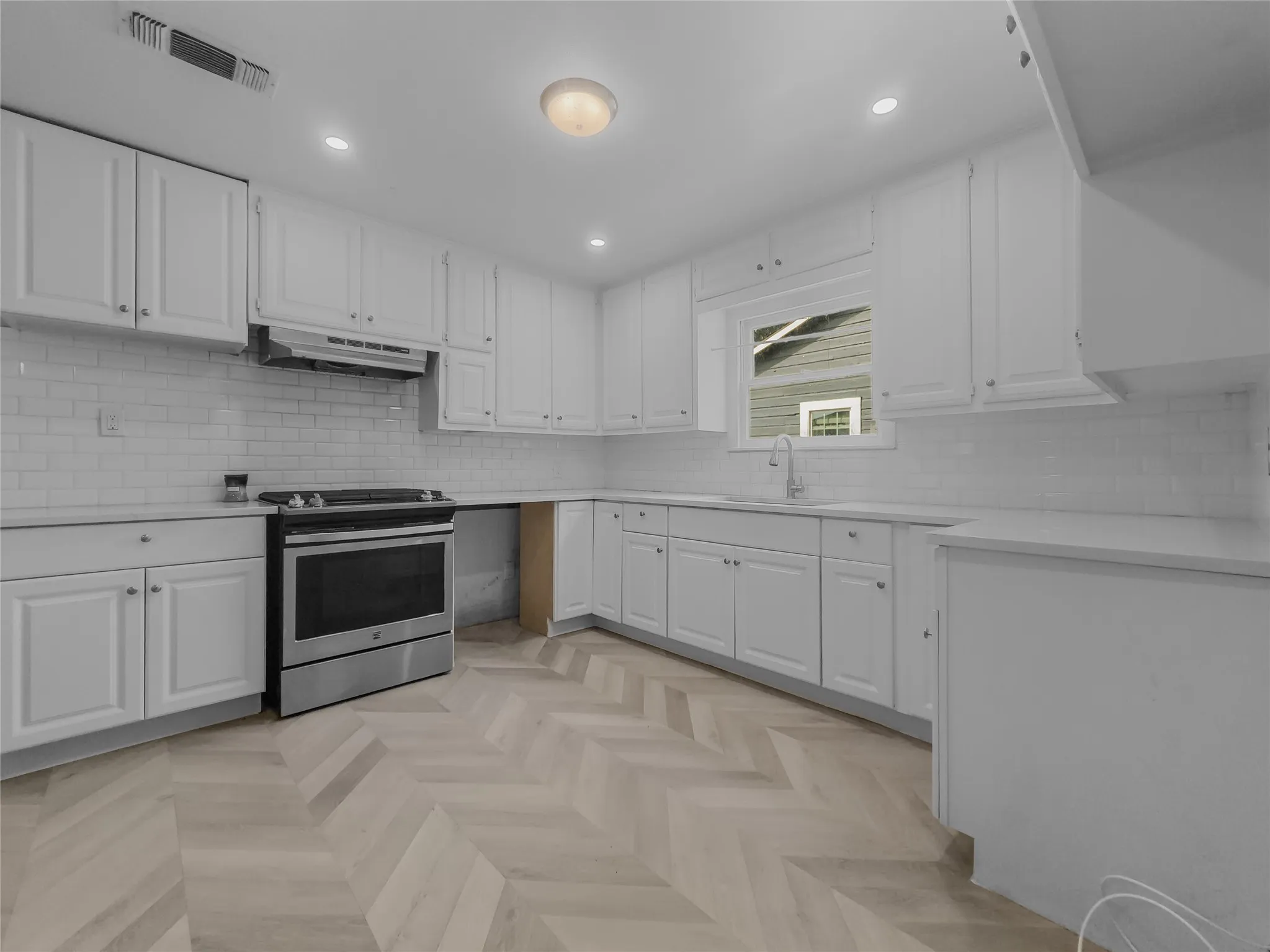 Kitchen with view of 3-sided cabinetry and gas stove top