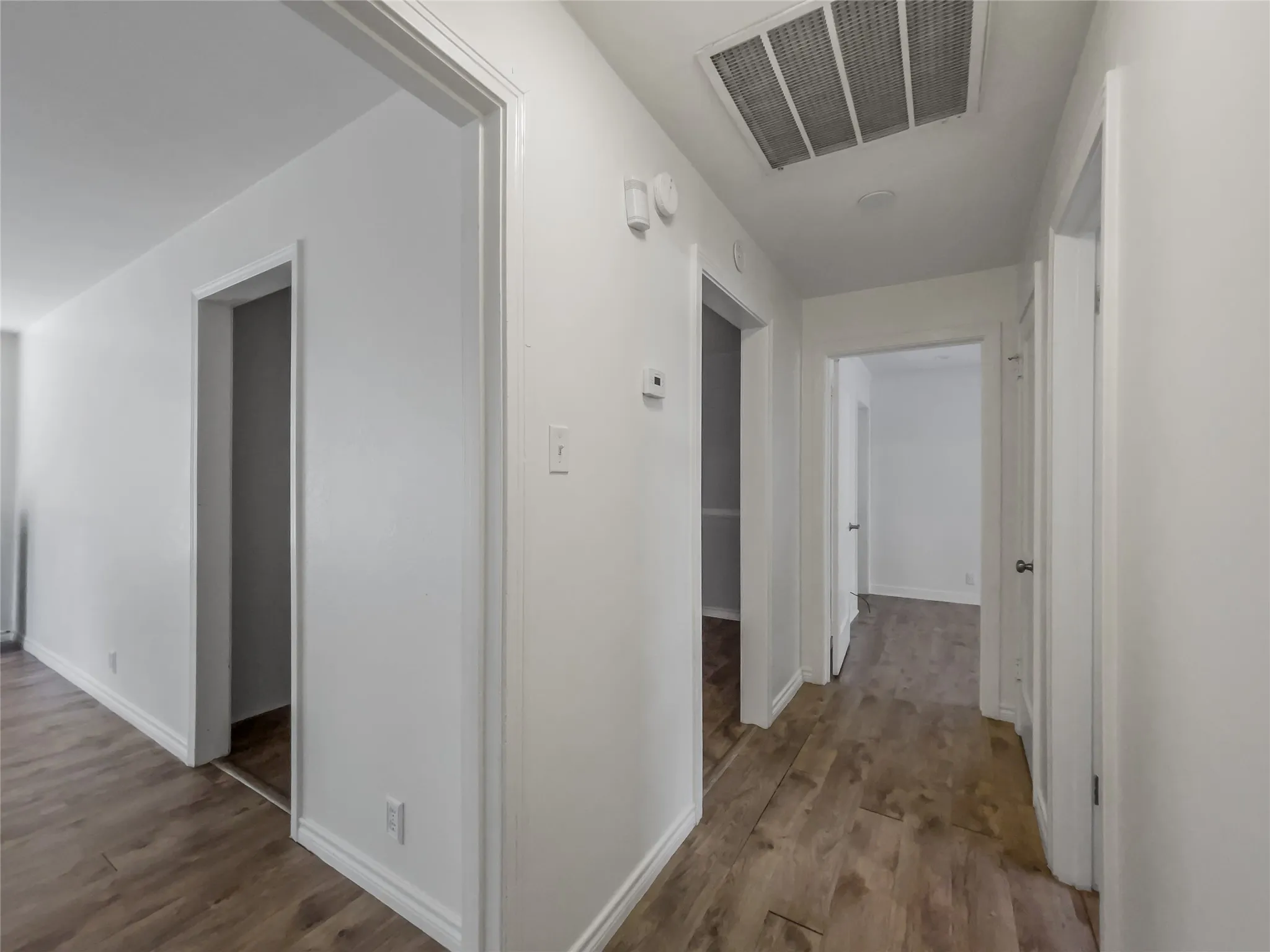 Hallway looking into living room and hall toward primary bedroom and second bathroom on the right