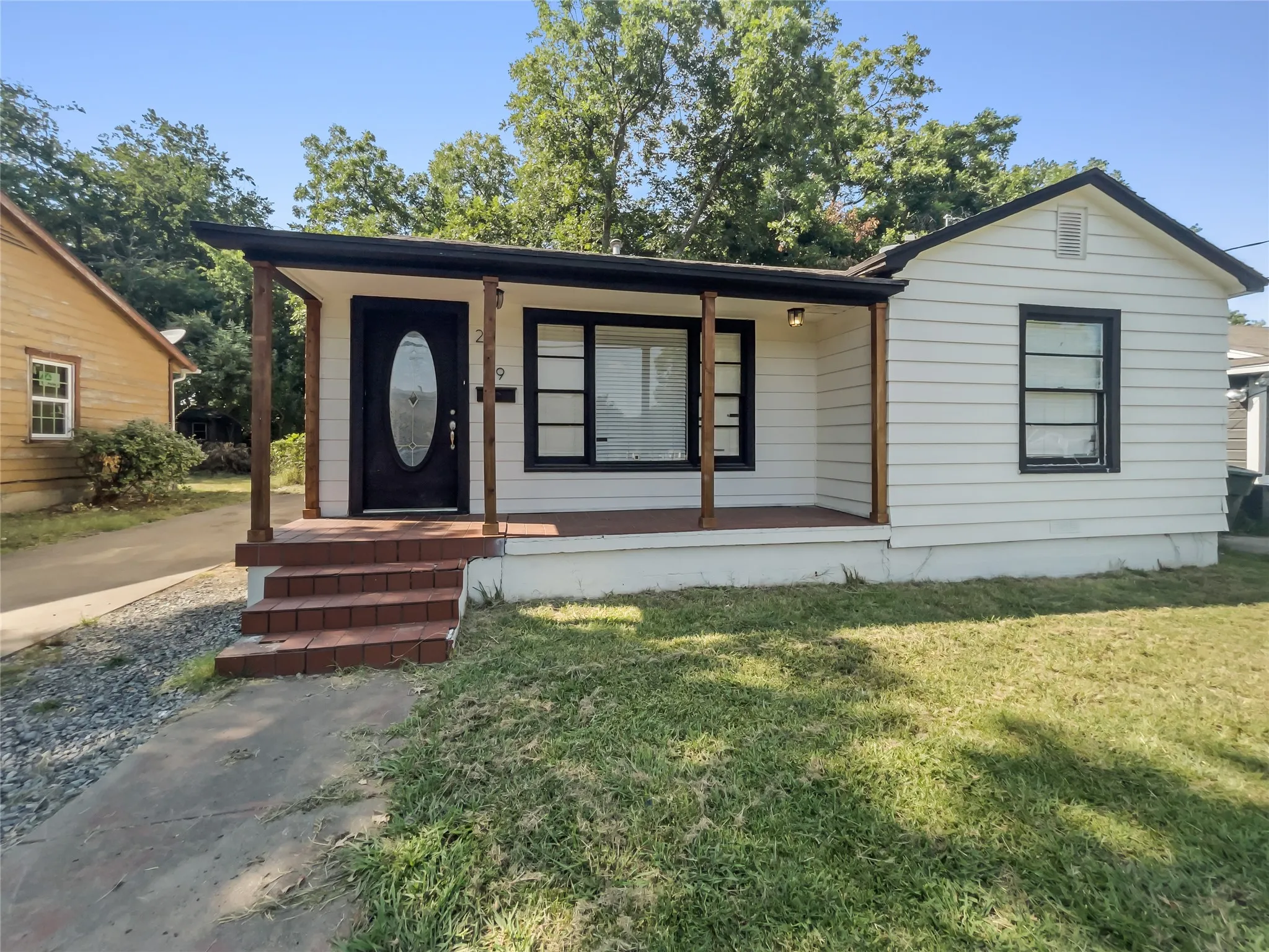 Front of home with covered front porch and driveway to the left
