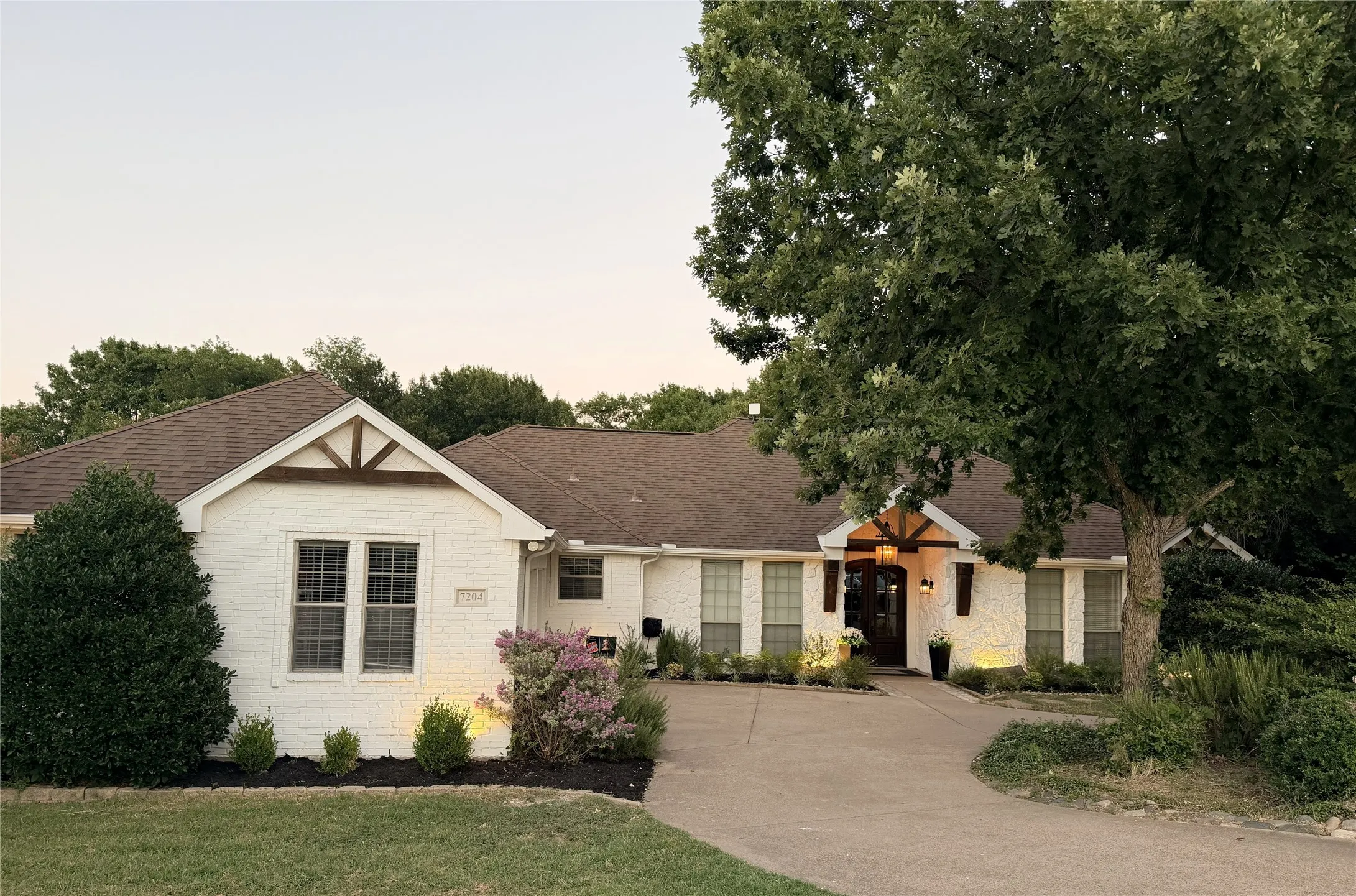 White brick exterior with a brown shingle roof
