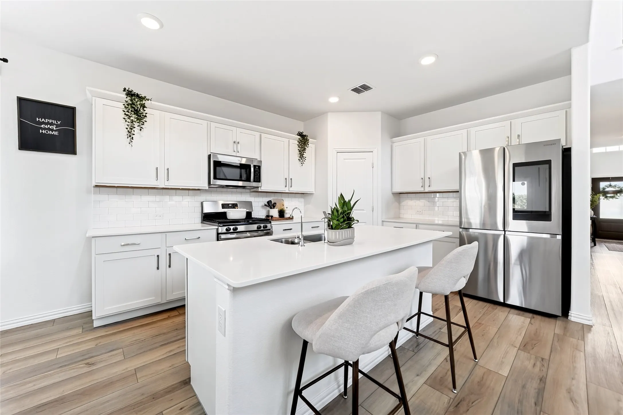 Bright kitchen with quartz counters and stainless steel applicances
