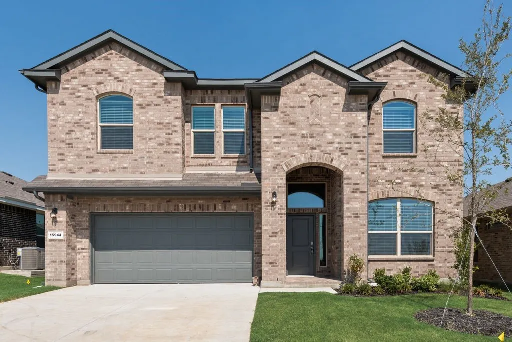 Stunning two-story brick residence featuring a traditional architectural design with multiple gabled rooflines and peaked dormers
