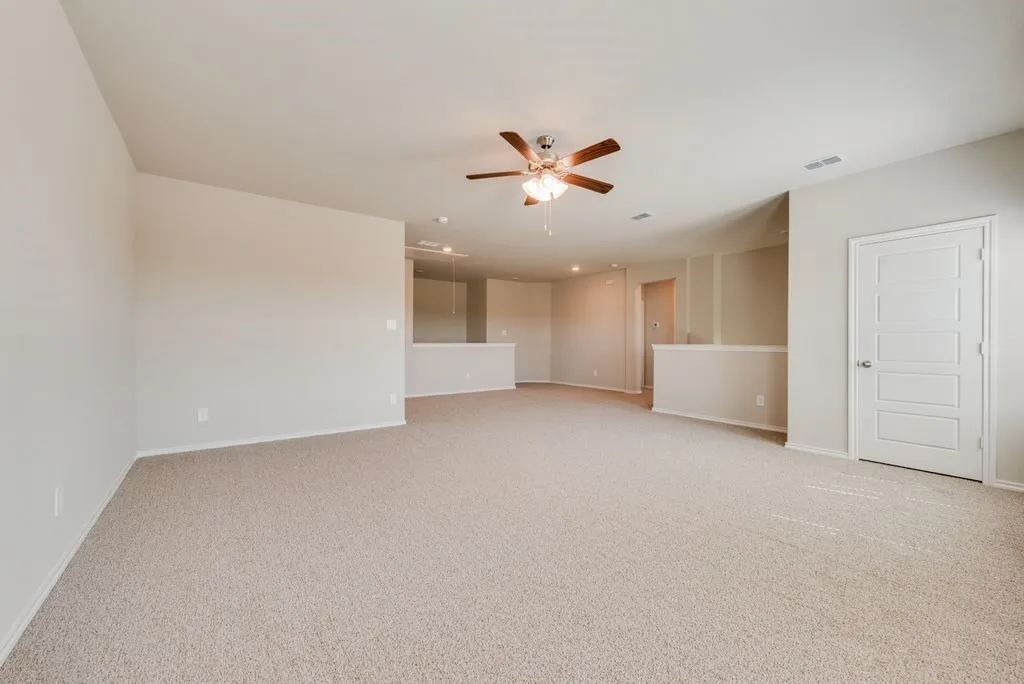 Spacious bonus room featuring neutral carpet flooring, recessed lighting, and a ceiling fan with integrated light fixture