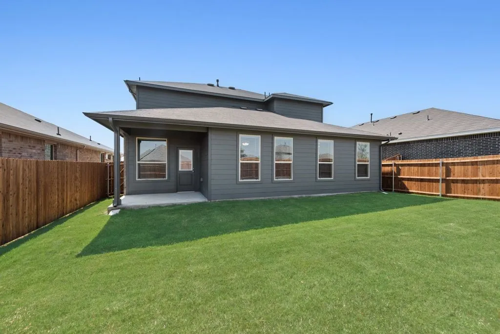 Modern home showcasing a spacious rear elevation with clean architectural lines, substantial windows providing natural light, and a generous manicured lawn