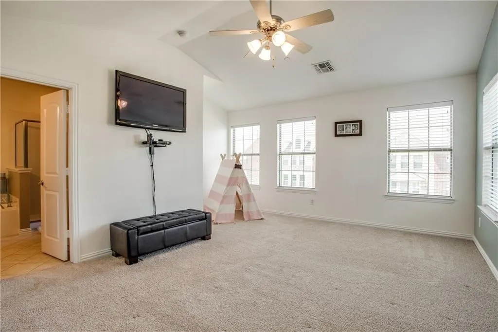 Game room featuring light carpet, lofted ceiling, baseboards, visible vents, and ceiling fan