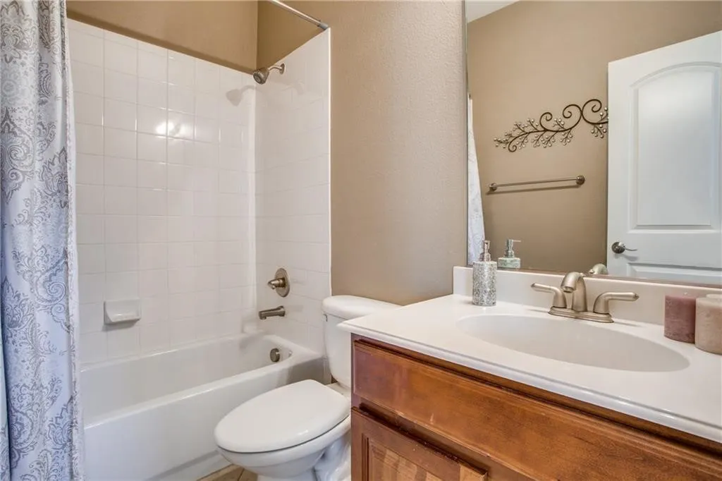 Bathroom with shower / tub combo with curtain, toilet, and vanity
