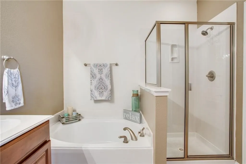 Bathroom with vanity, a garden tub, and a shower stall