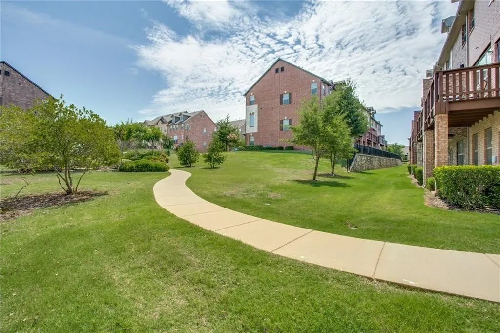 View of home's community with a lawn