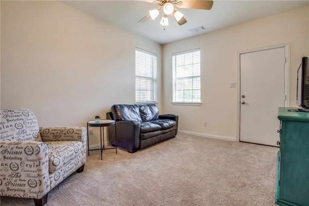 Sitting room featuring baseboards, visible vents, ceiling fan, and carpet flooring