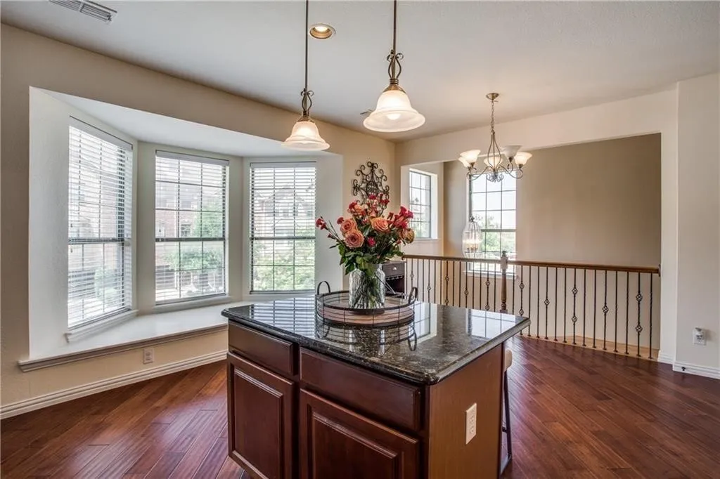 Kitchen with dark wood-style floors, visible vents, pendant lighting, and a chandelier