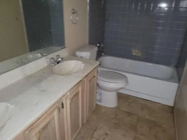 Bathroom vanity featuring a shell-shaped sink, chrome faucet, and expansive mirror