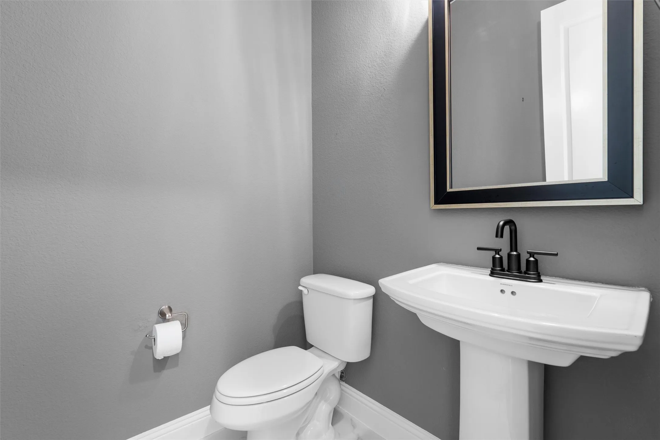 Powder room perfection! ?? Loving the classic pedestal sink and that sleek black framed mirror. Small space, big style! ??? #PowderRoom #BathroomInspo #SmallSpaces